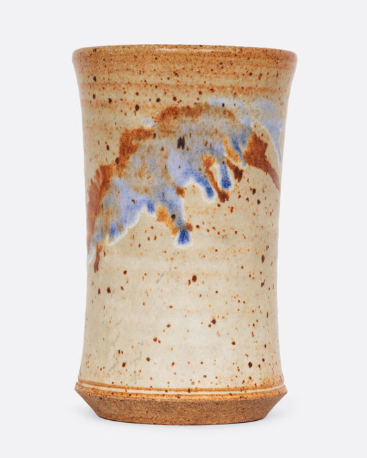 A tall speckled vessel with blue and brown splattered glaze. Shown from the front.