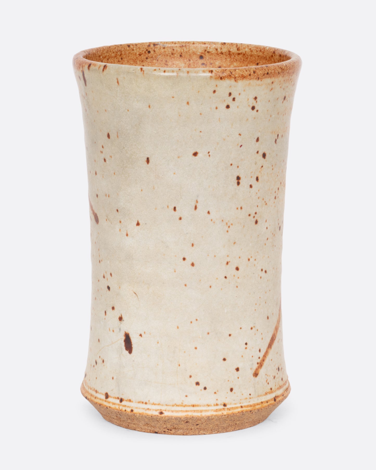 A tall speckled vessel with blue and brown splattered glaze. Shown from the back.