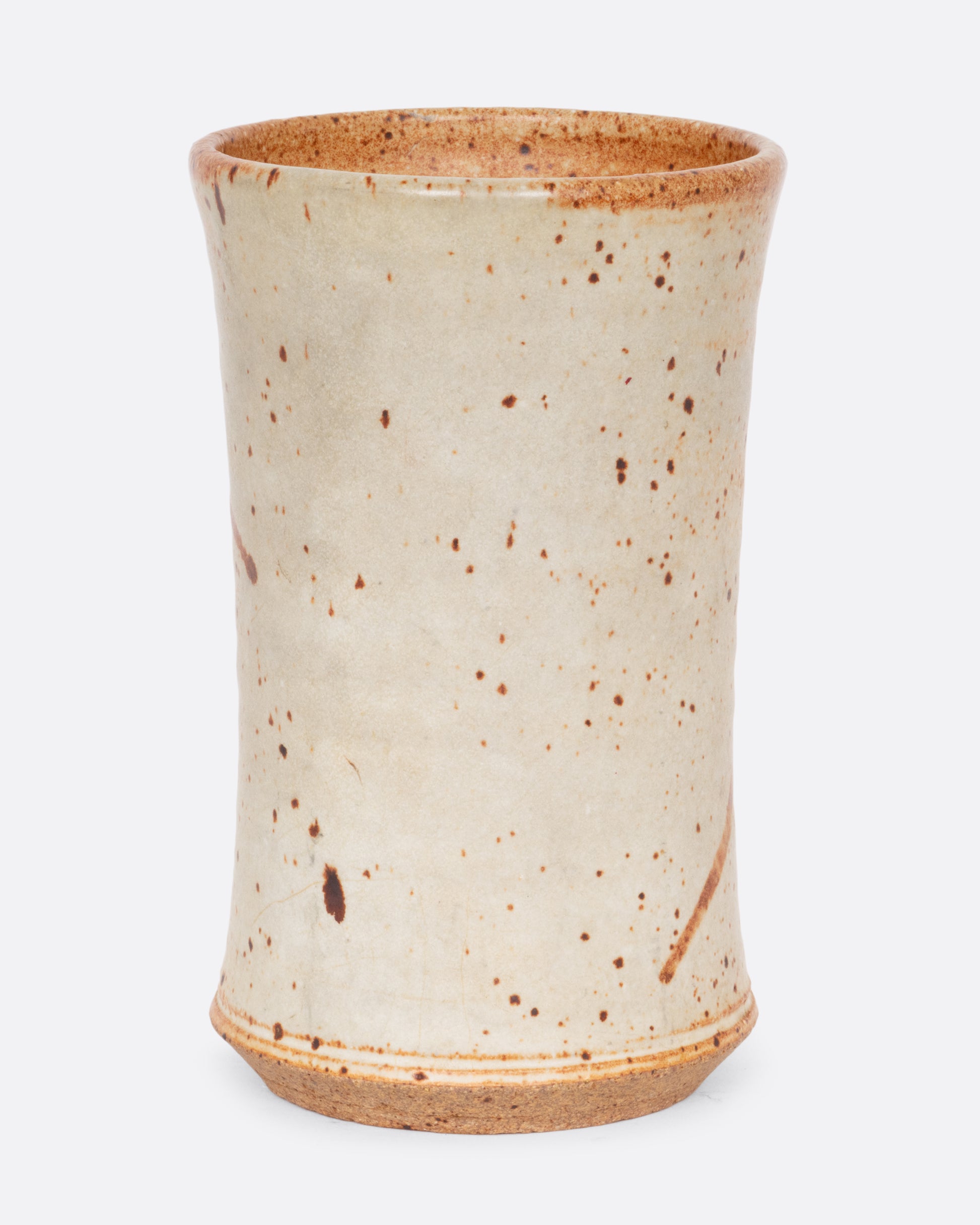 A tall speckled vessel with blue and brown splattered glaze. Shown from the back.