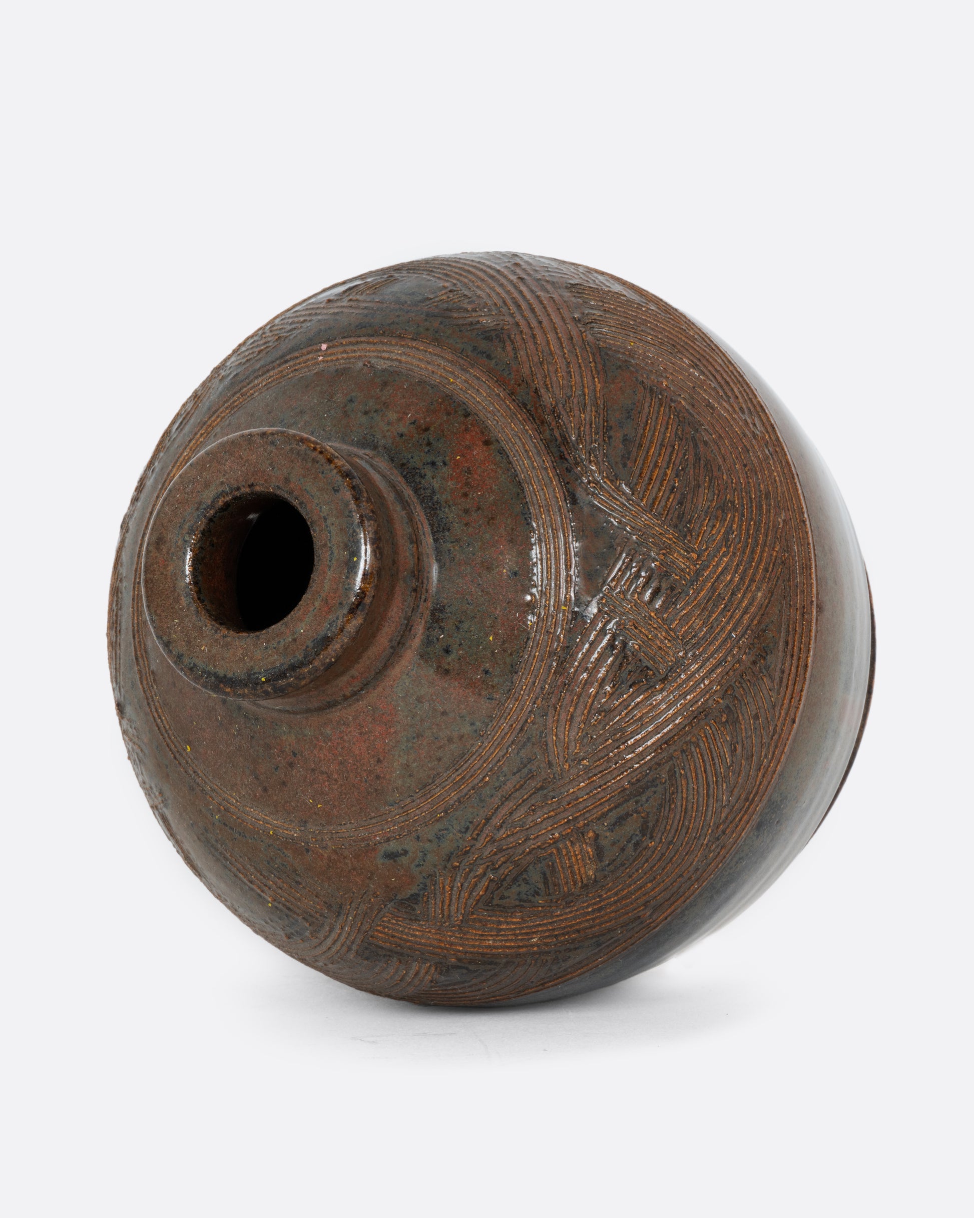 A round vase with a braided motif and brown glaze. Shown on its side from the top.