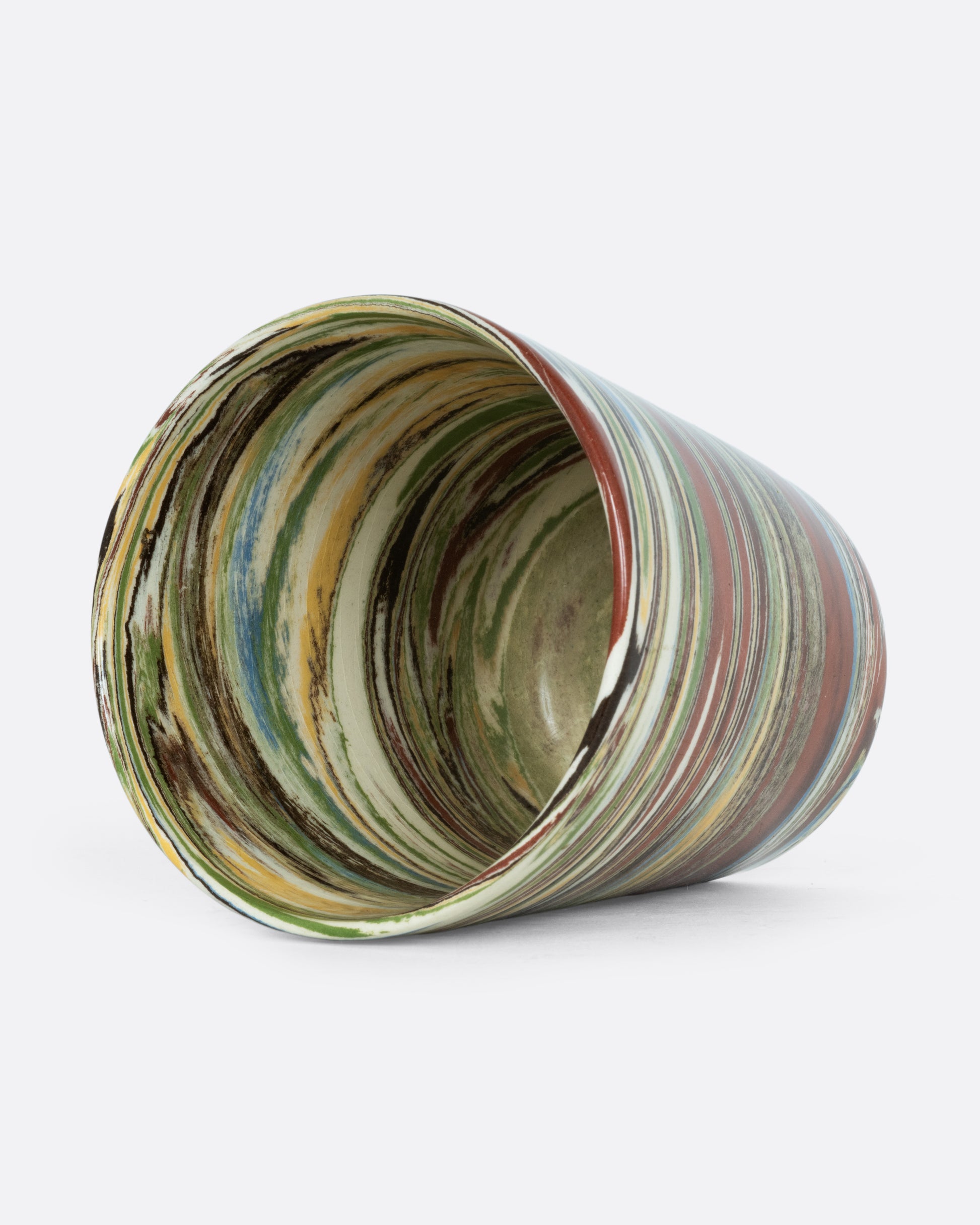  A ceramic Nerikomi cup with multicolored swirls. Shown on its side from the top.