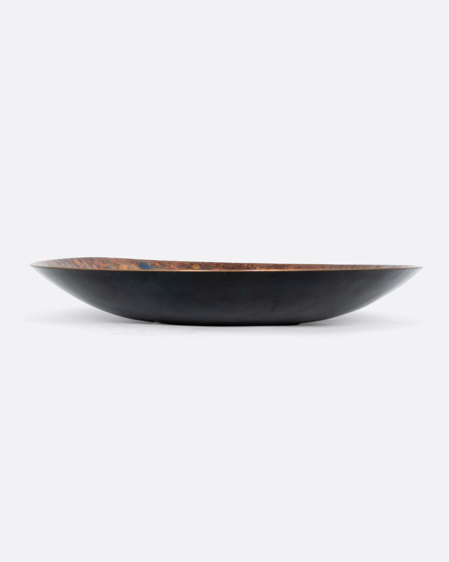  A colorful spotted enamel plate. Shown from the side.