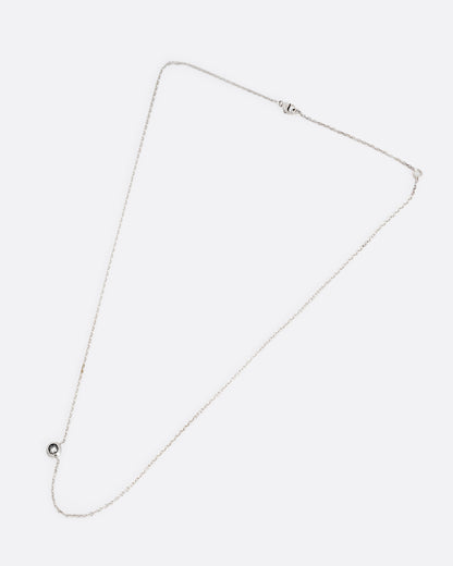 A silver cable chain necklace with a reverse set grey diamond. Shown clasped lying flat.