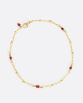 A yellow gold twisted paperclip chain link bracelet with five ruby beads.Shown clasped from the top.