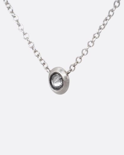 A silver cable chain necklace with a reverse set grey diamond. Shown from the front.