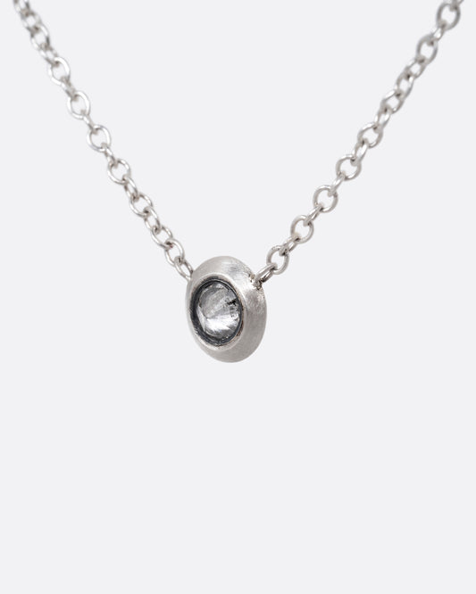 A silver cable chain necklace with a reverse set grey diamond. Shown from the front.