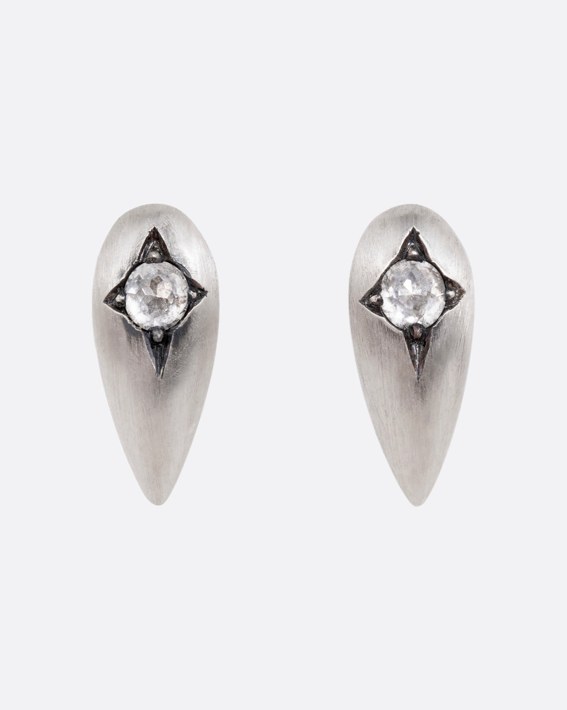 Silver teardrop shaped earrings with rose cut diamonds. Shown from the front.