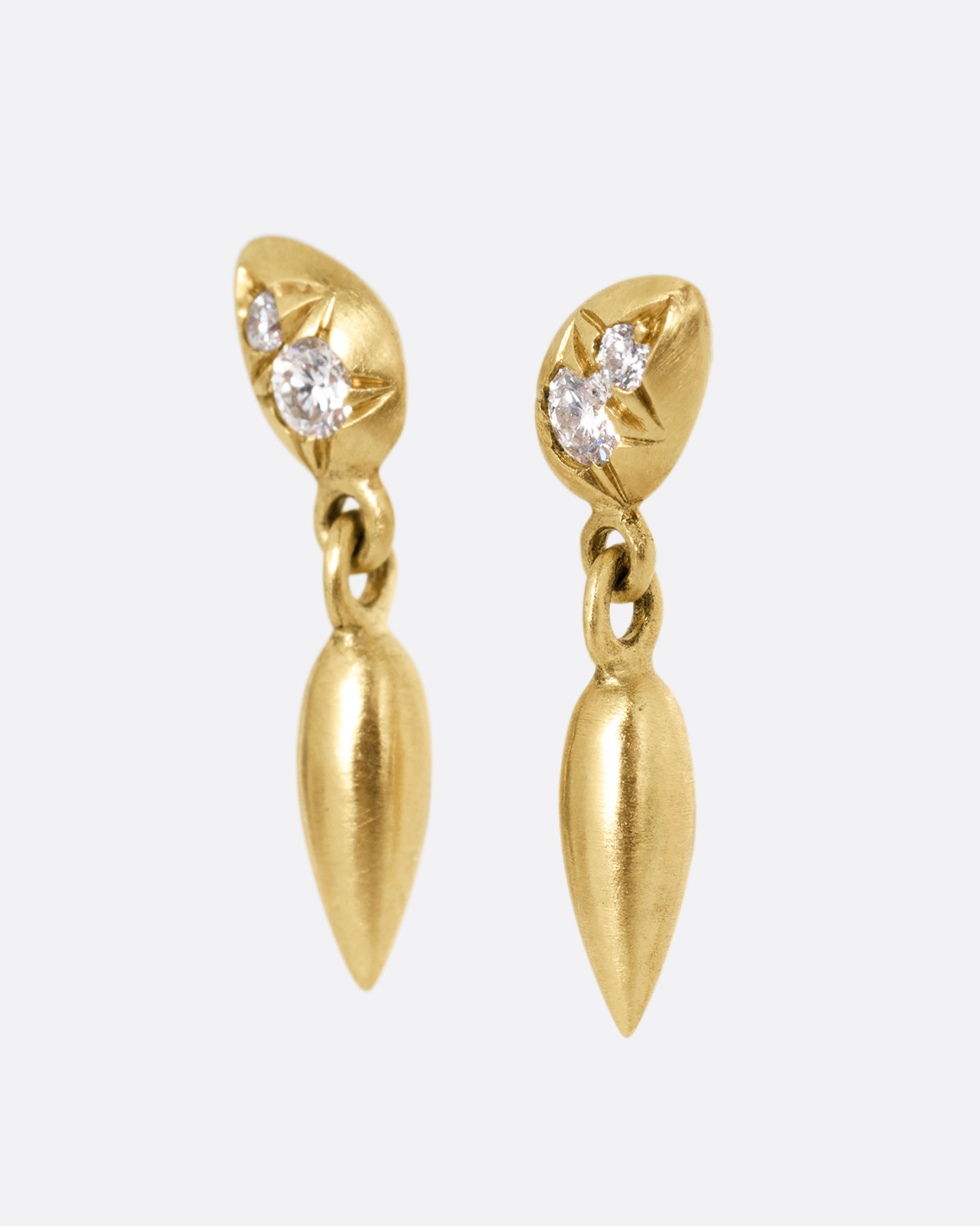 Yellow gold diamond earrings with teardrop shaped dangles. Shown from the side.