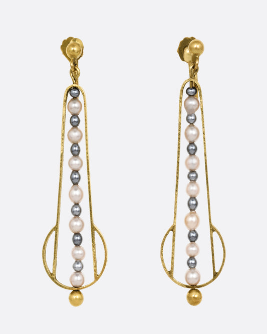 Yellow gold geometric dangle earrings with screw clasps and pearls down the center. Shown from the front.