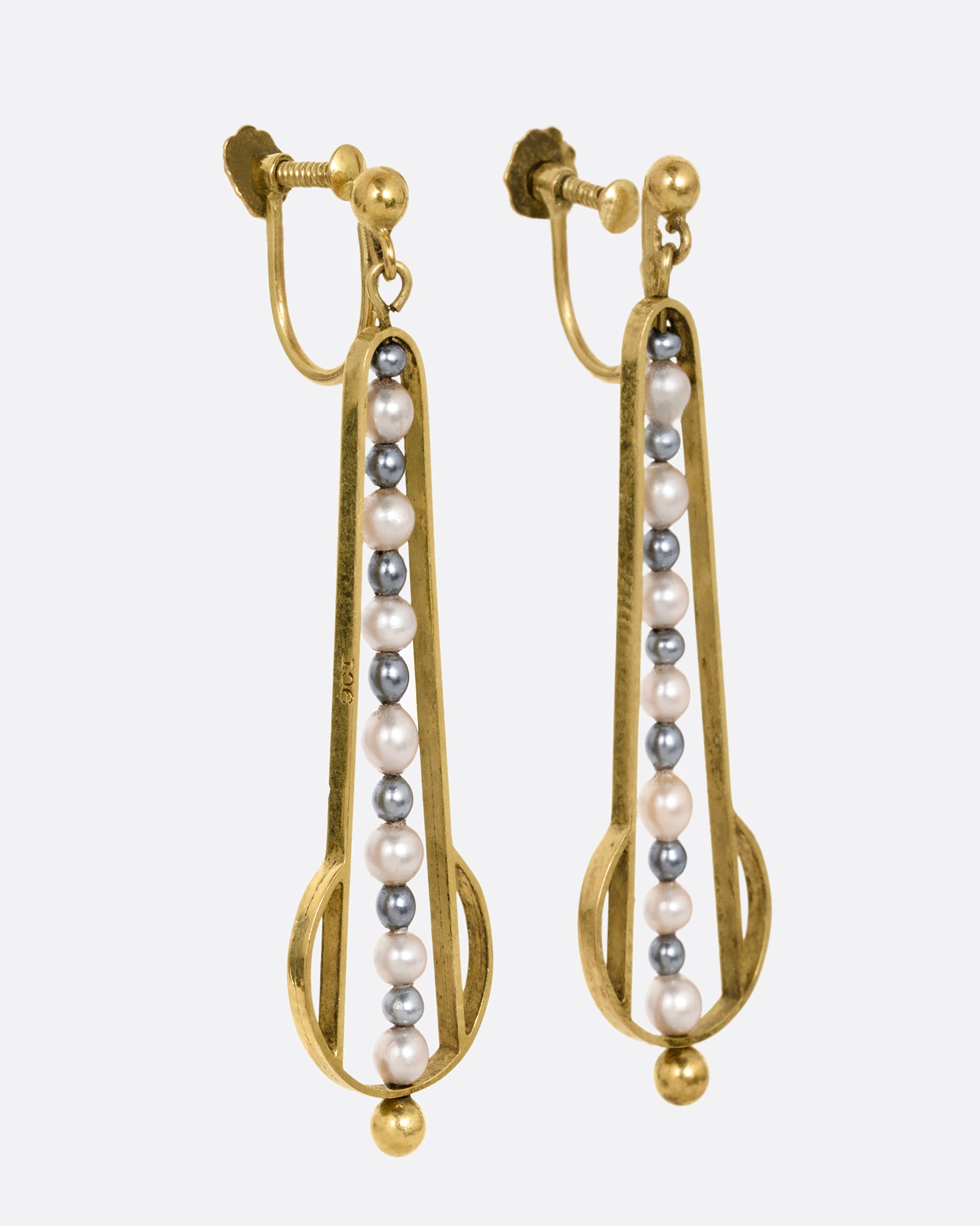 Yellow gold geometric dangle earrings with screw clasps and pearls down the center. Shown from the side.