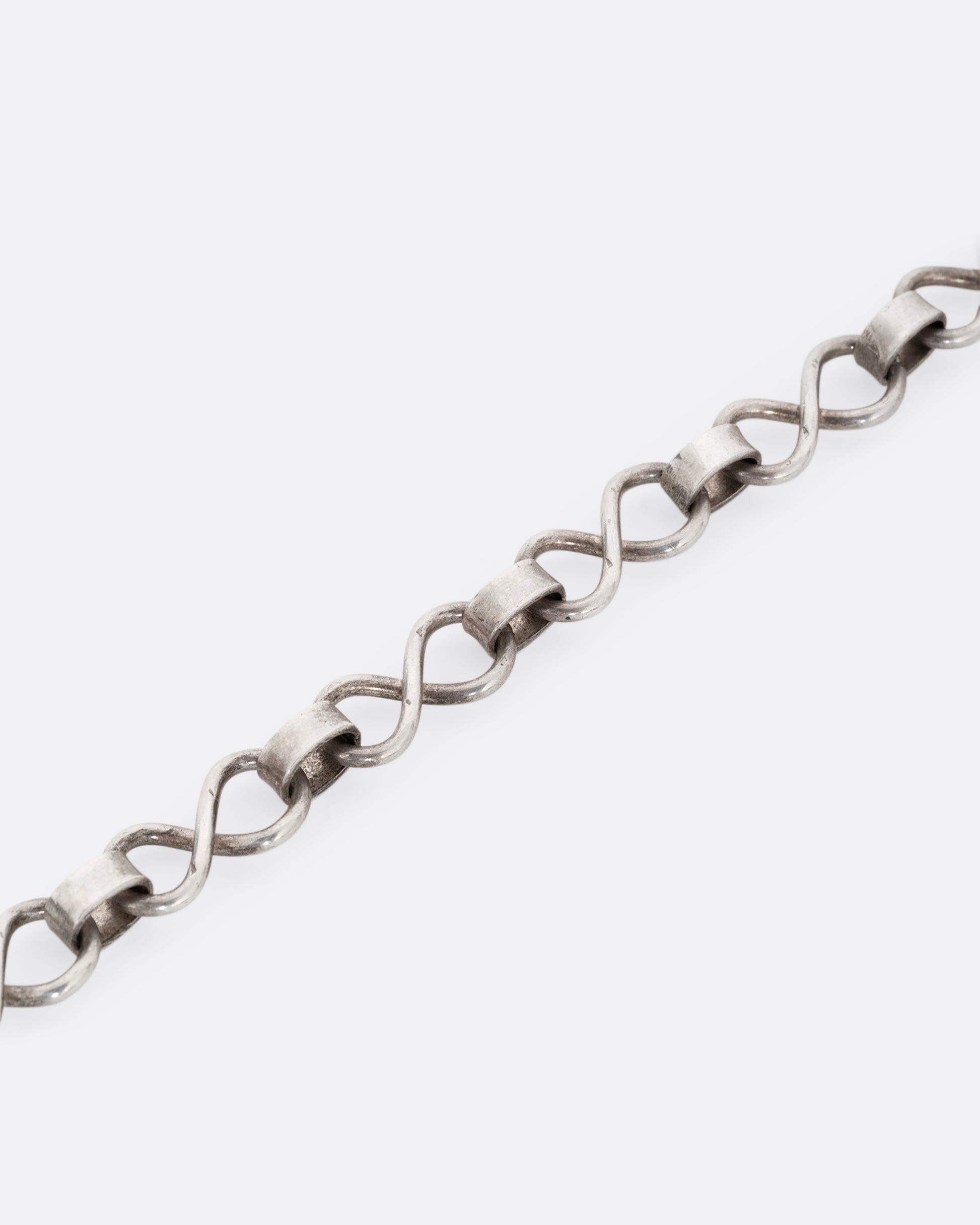 A silver infinity link necklace. Shown close up.