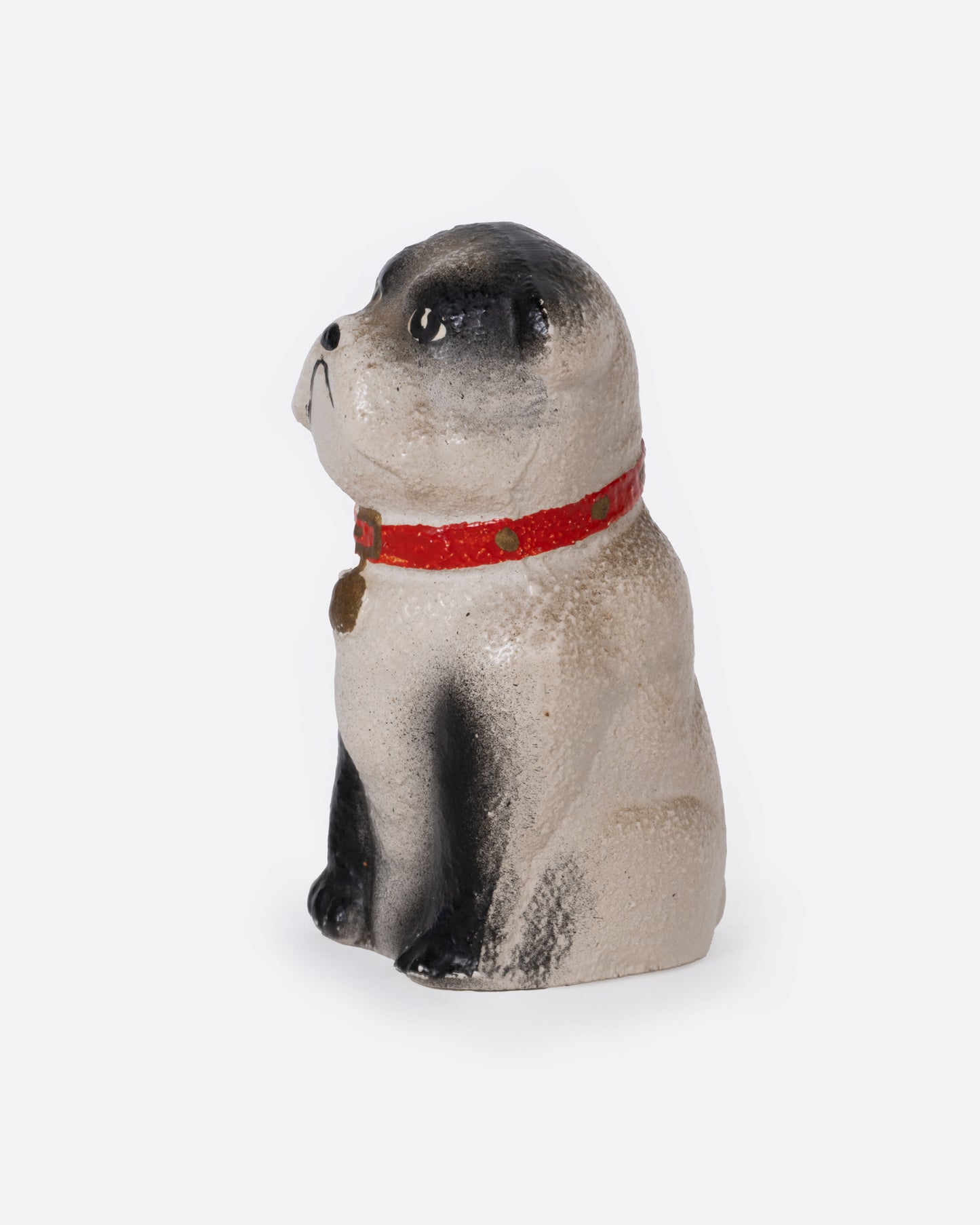 A bull dog figurine with a red collar, shown from the side.