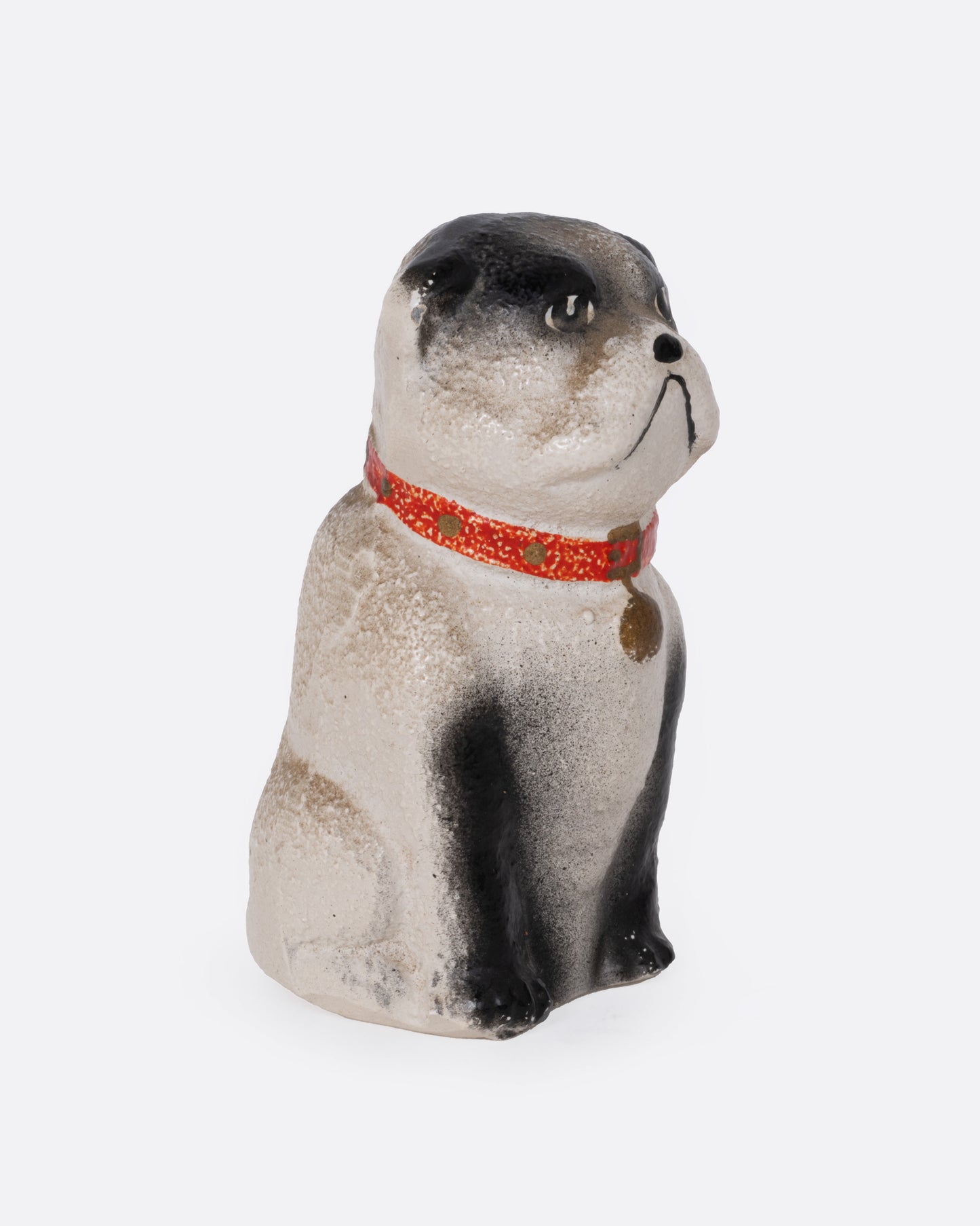 A bull dog figurine with a red collar, shown from the side.