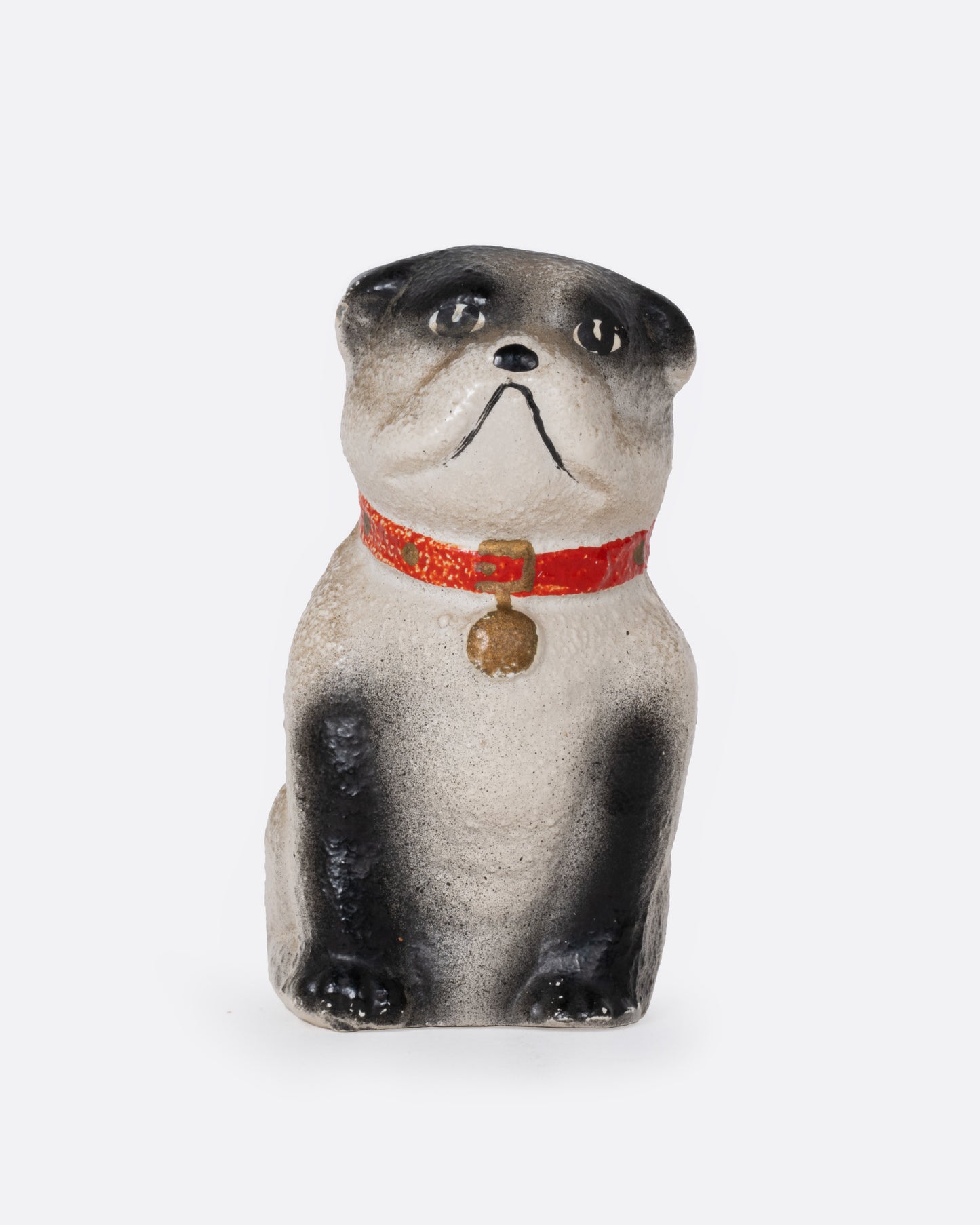 A bull dog figurine with a red collar, shown from the front.