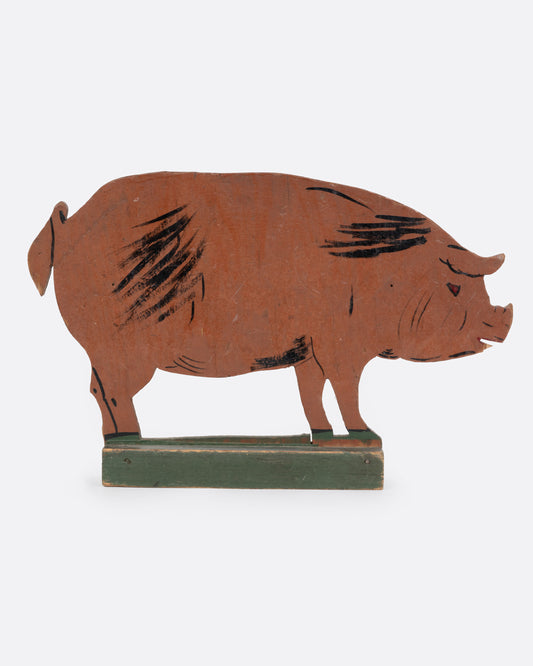 A wooden pig cutout figure, shown from the side.