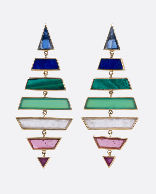A pair of yellow gold kite shaped drop earrings with multi-colored hand cut stones, shown from the front.