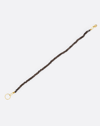 A beaded smoky quartz bracelet with a yellow gold clasp. Shown from the front.