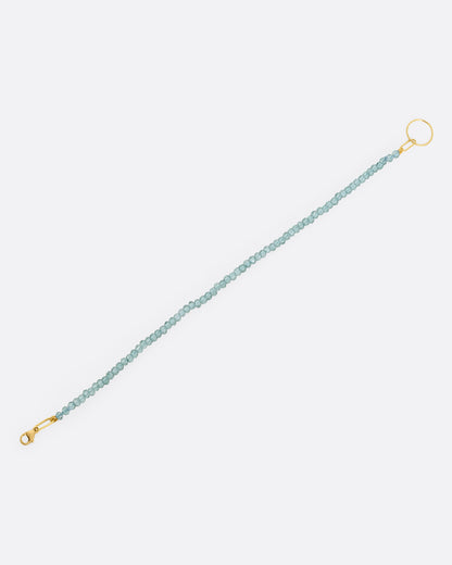 Green quartz bead bracelet with yellow gold clasp laid out straight, showing the full length