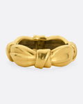 A yellow gold ring with bow knots throughout. Shown from the front.