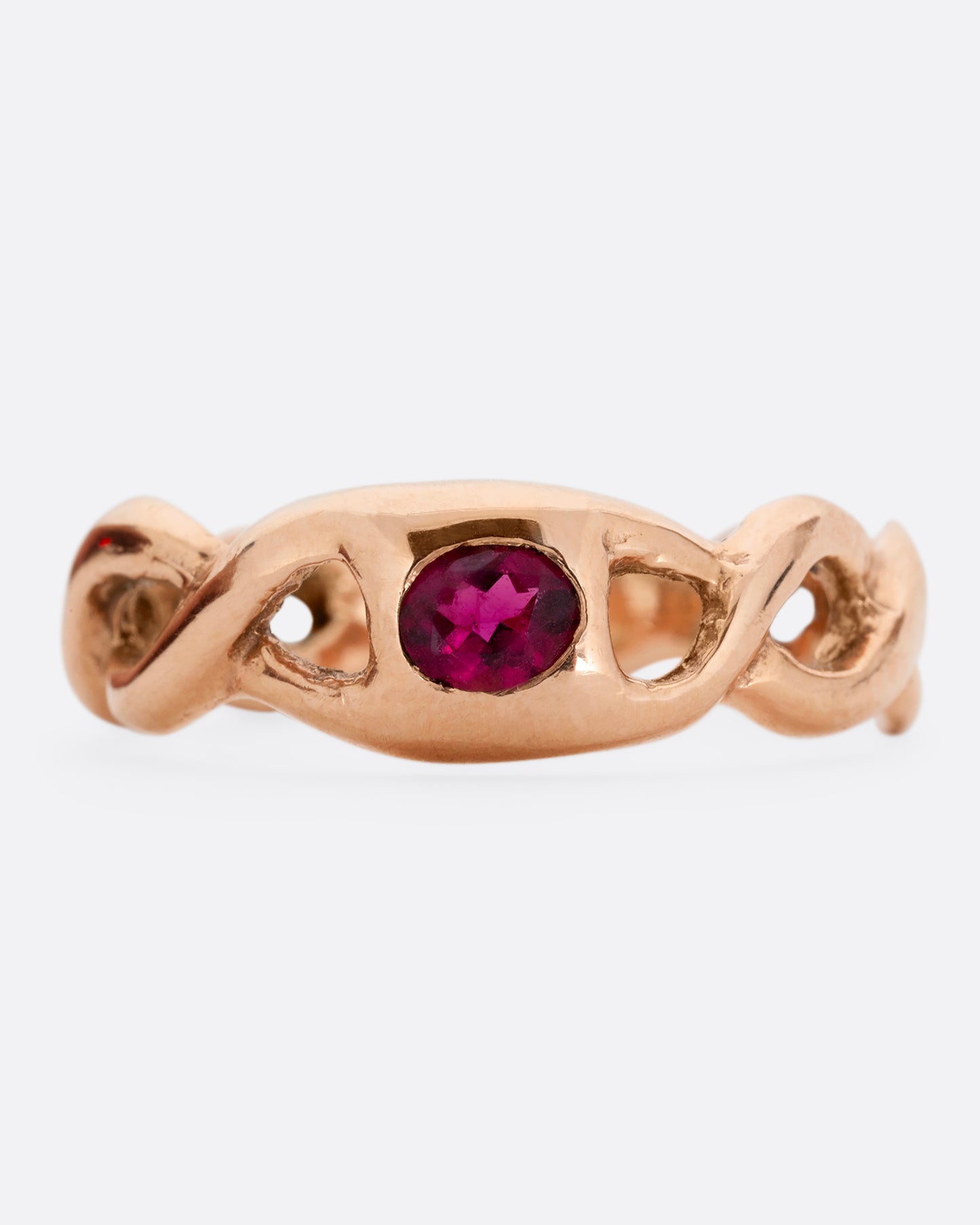A rose gold ring with a twisted motif and pink tourmaline at the center. Shown from the front.