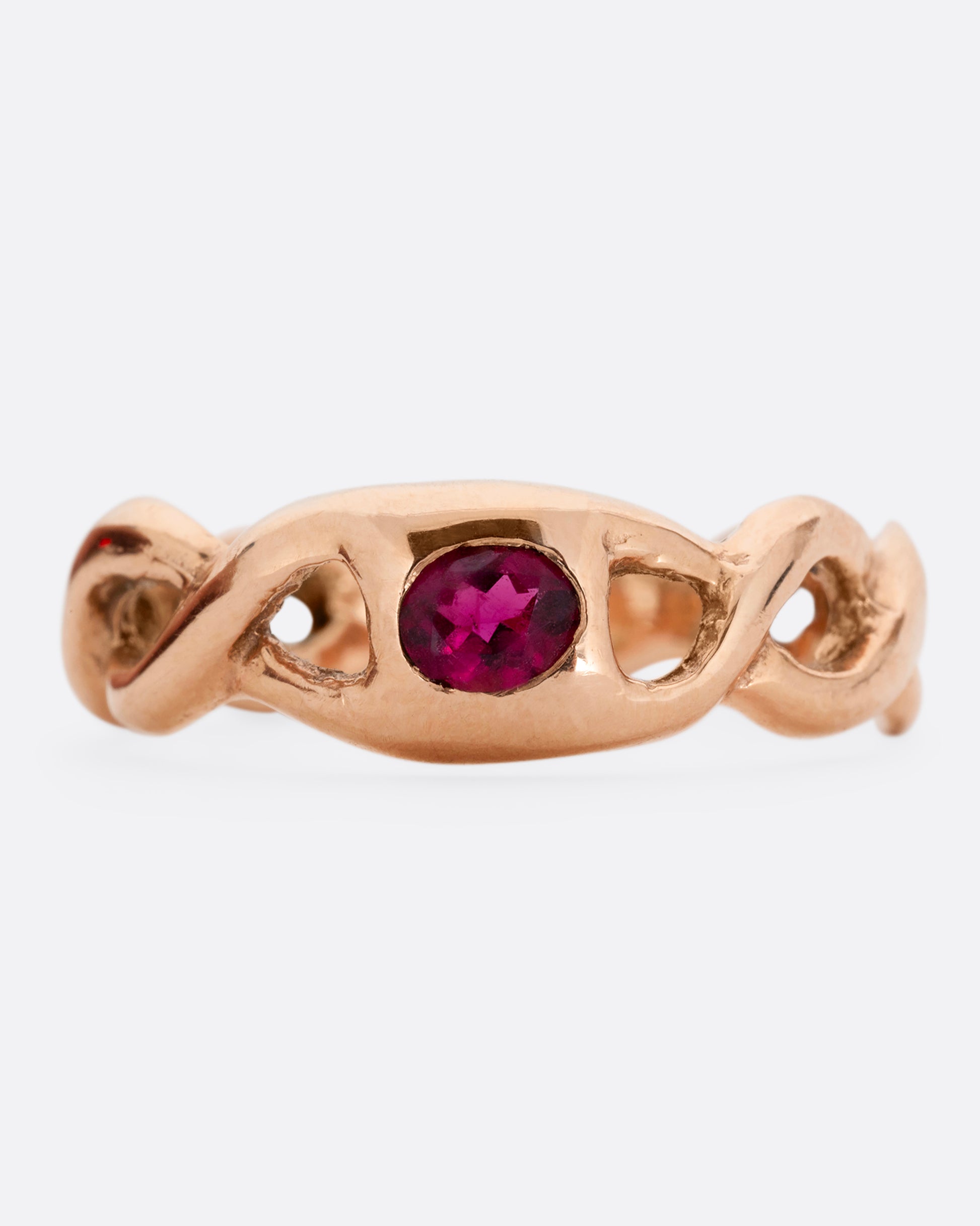 A rose gold ring with a twisted motif and pink tourmaline at the center. Shown from the front.