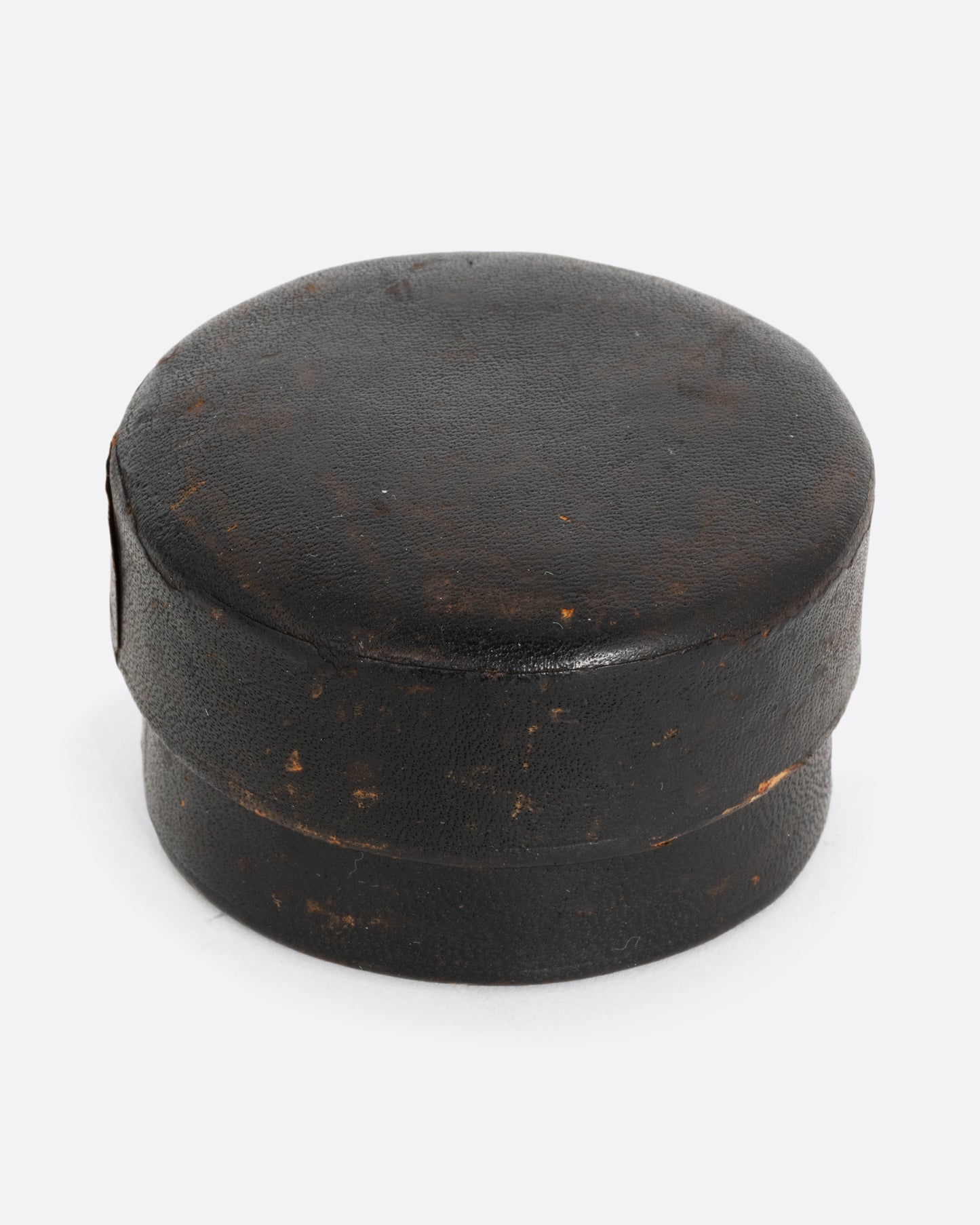 A round leather case for a collapsible cup. Shown from the front.