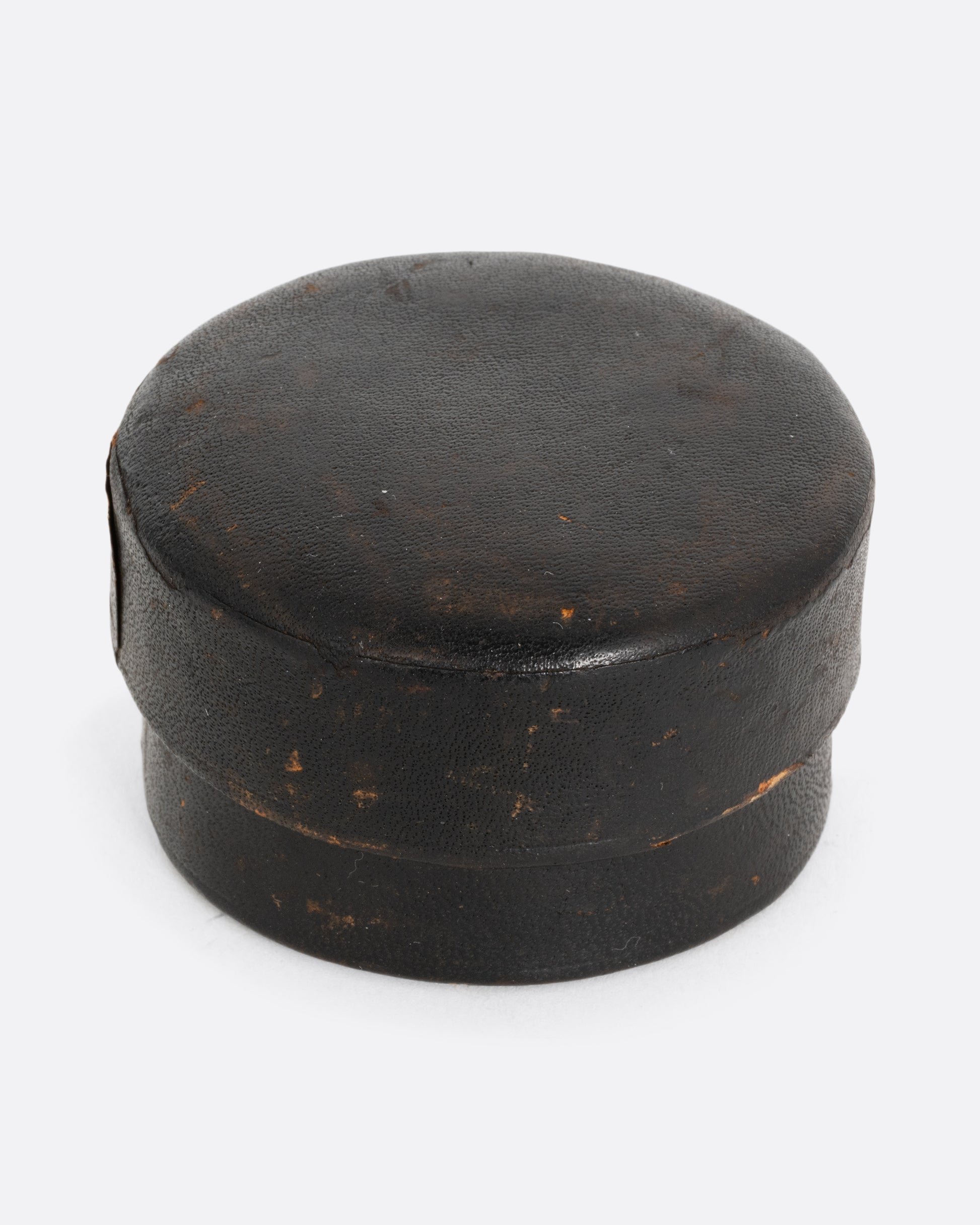 A round leather case for a collapsible cup. Shown from the front.