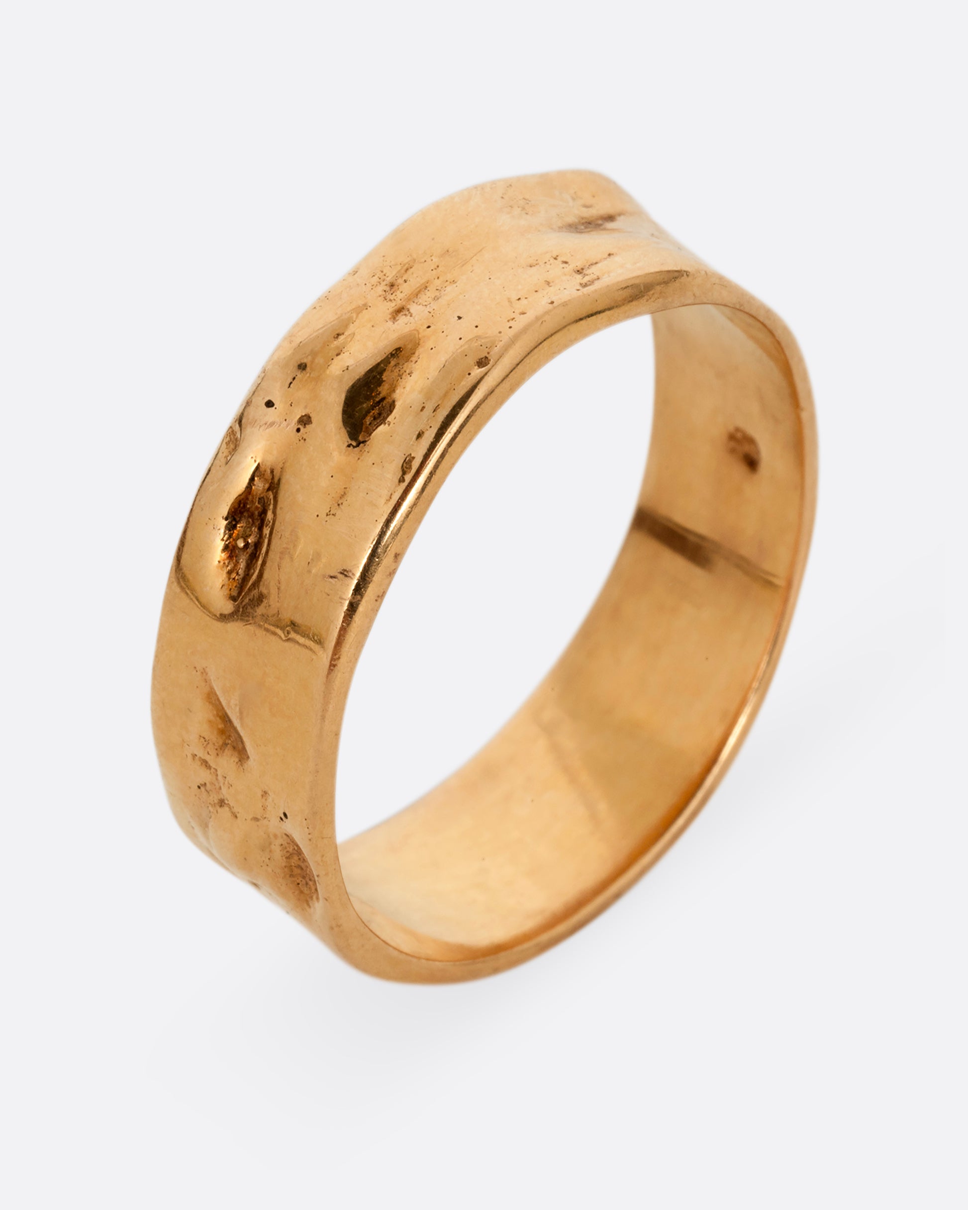 A rose gold band with a textured and polished finish. Shown standing up from the side.
