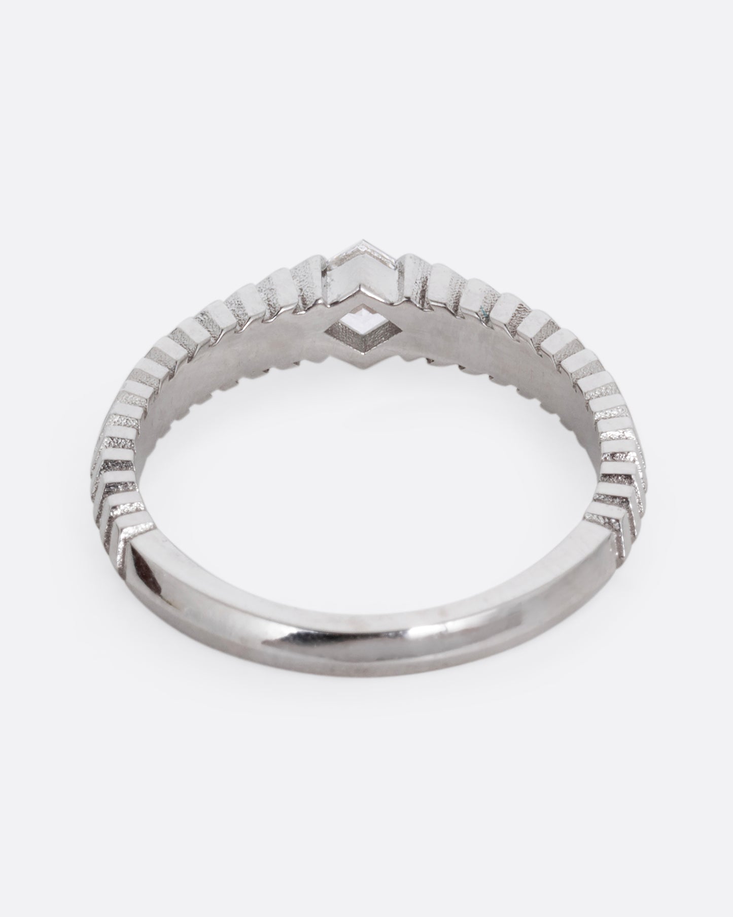 A platinum ring with a 'pleated' motif and lozenge shaped diamond at the center. Shown from the back.
