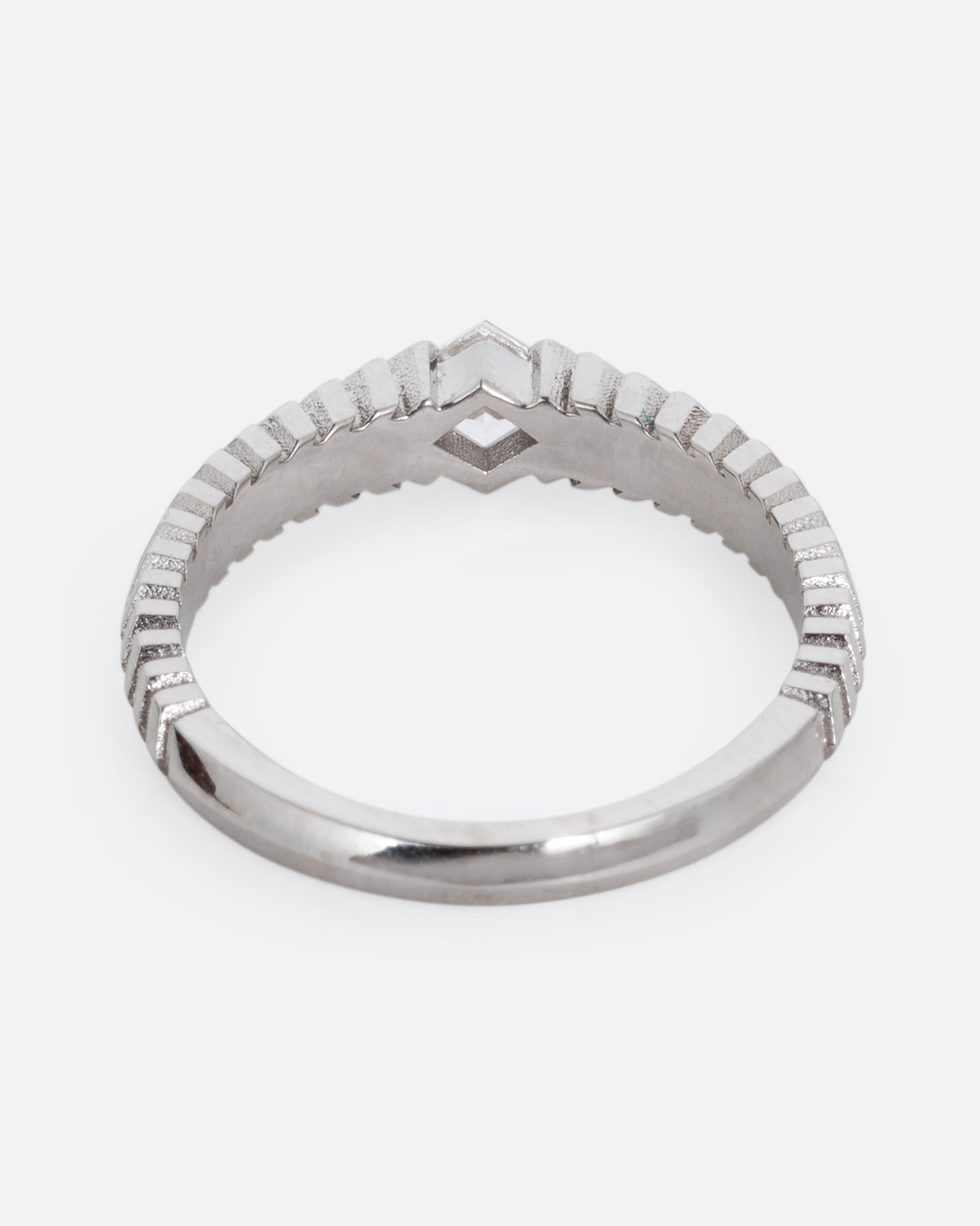 A platinum ring with a 'pleated' motif and lozenge shaped diamond at the center. Shown from the back.