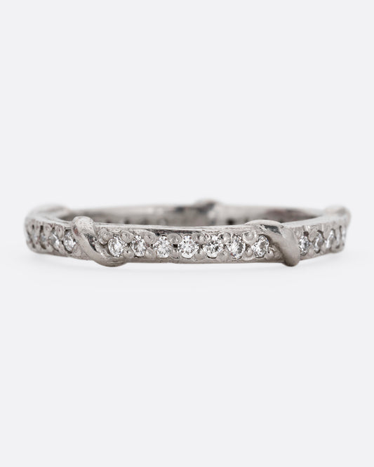 A platinum eternity band with vine detailing and brilliant white diamonds. Shown from the front.