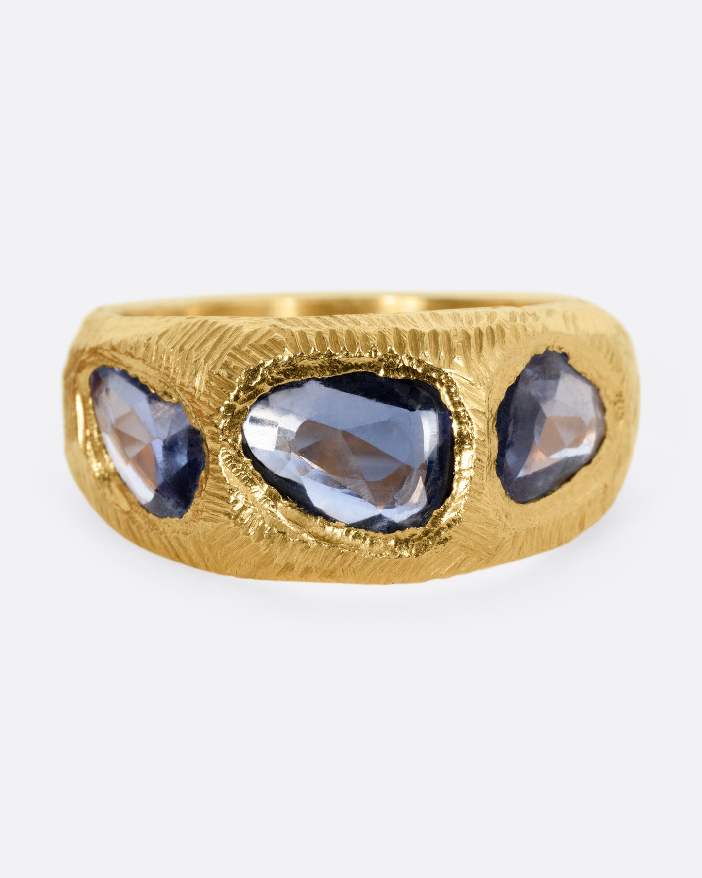 A yellow gold ring with three blue sapphires, shown from the front.