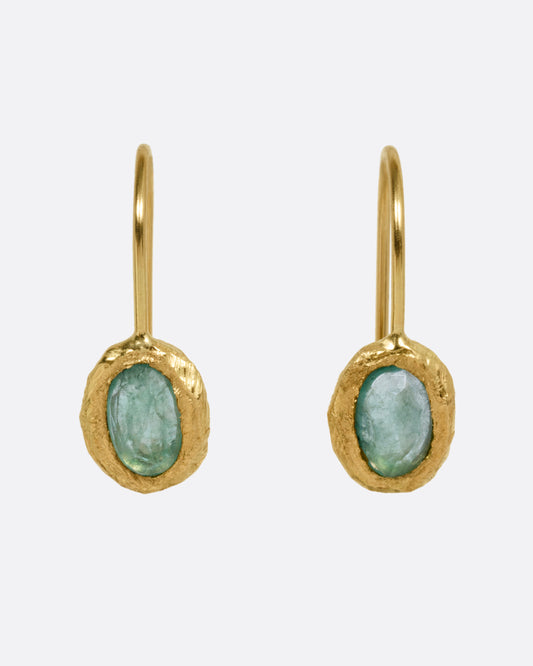 A pair of yellow gold hook earrings with emeralds, shown from the front.