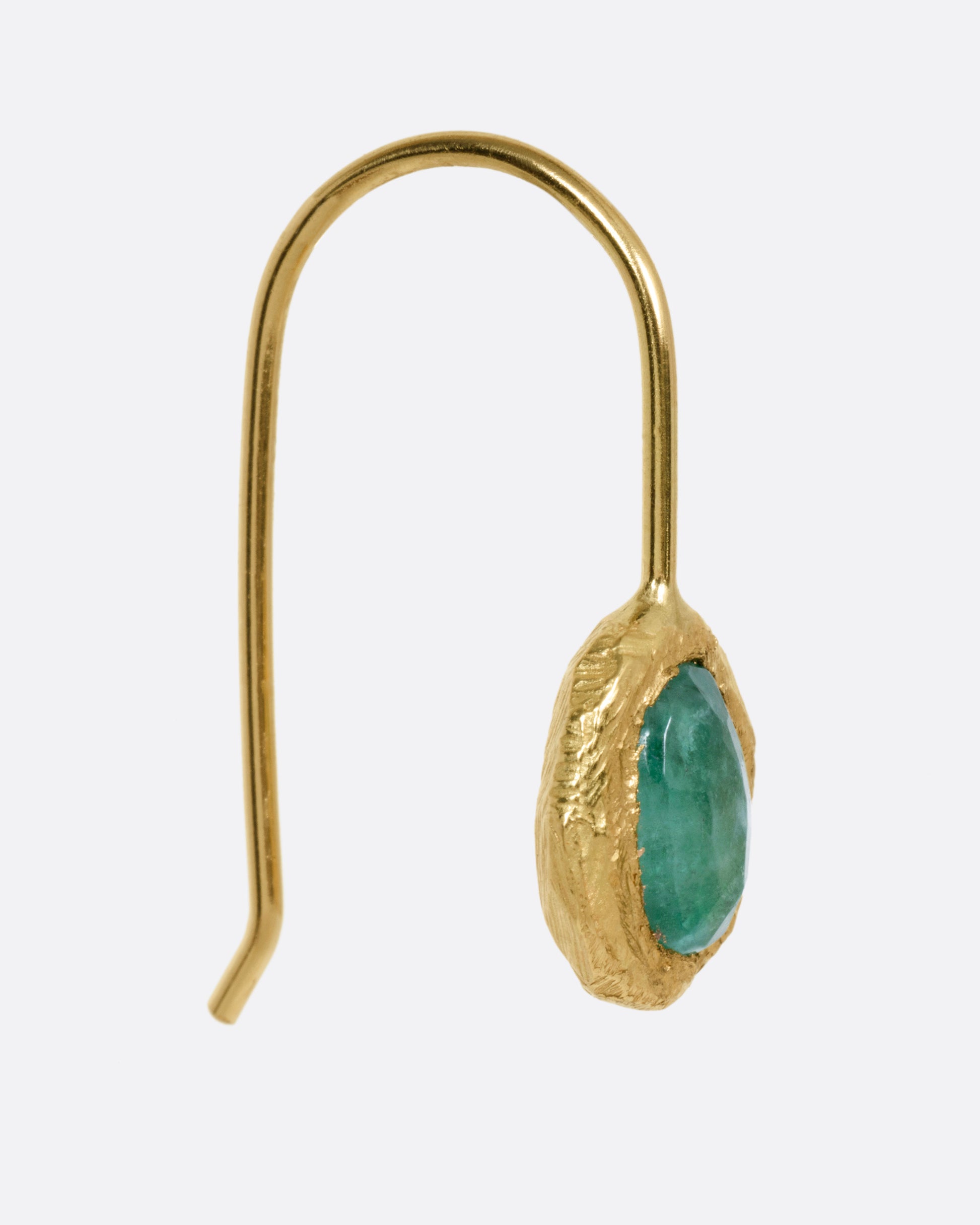 A yellow gold hook earring with an emerald, shown from the front.
