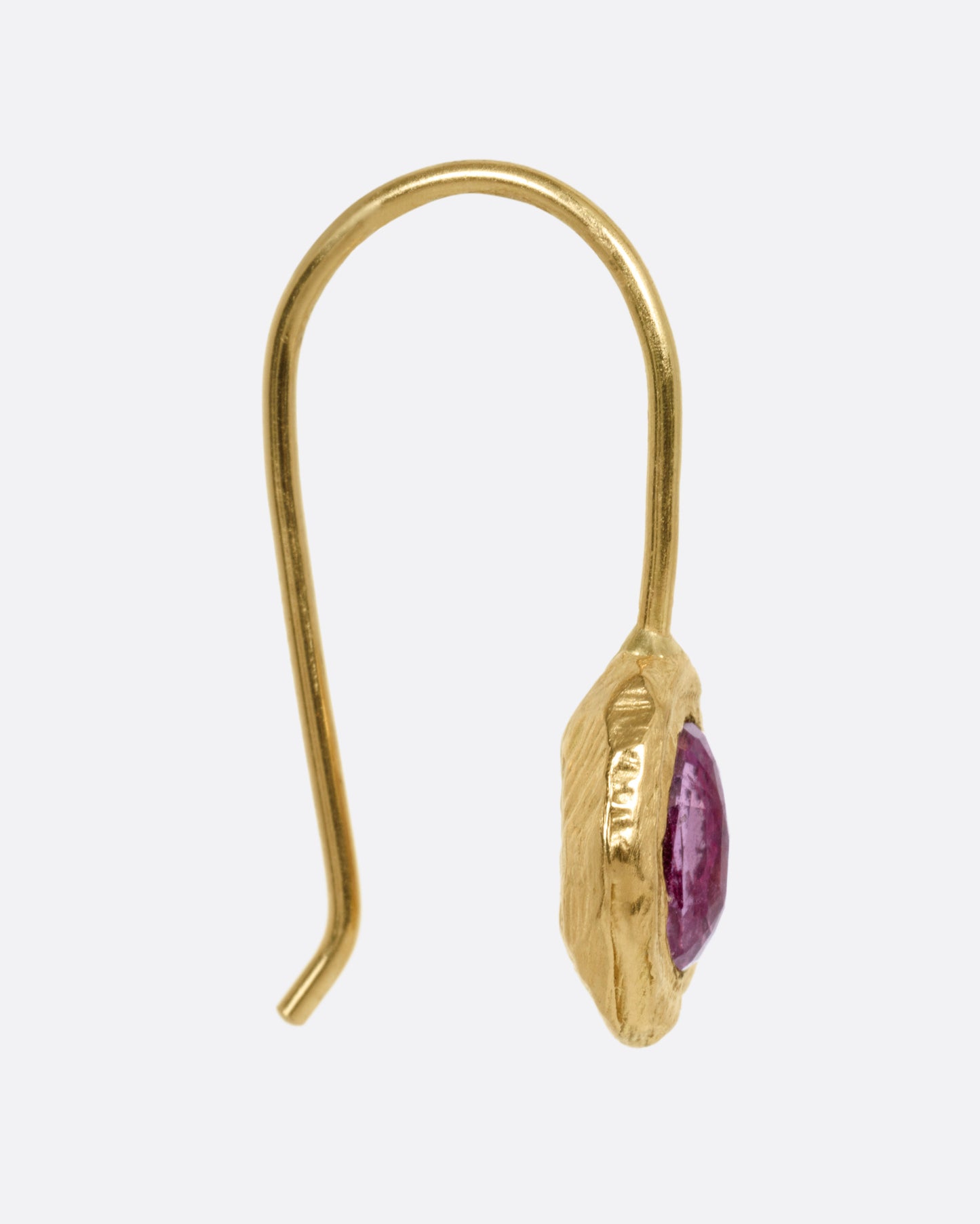 A yellow gold earring with a pink sapphire, shown from the side.