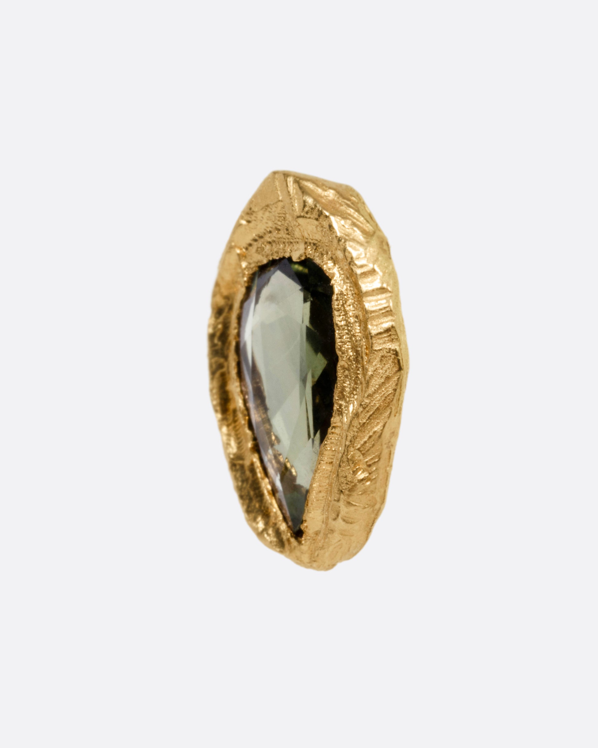 A yellow gold stud earring with a teardrop shaped green sapphire, shown from the side.