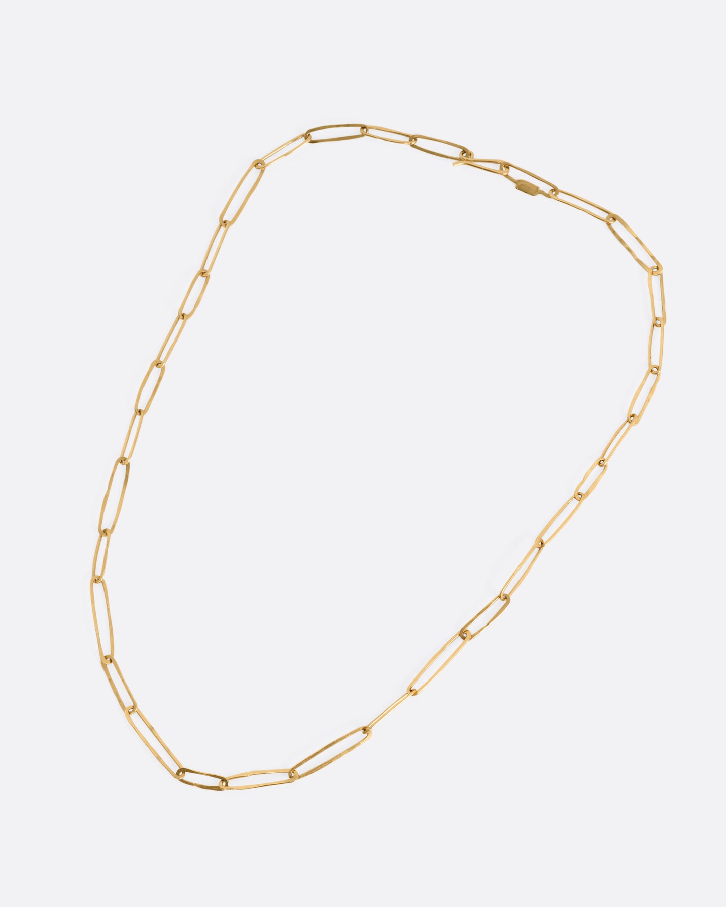 A yellow gold paperclip chain shown from the front.
