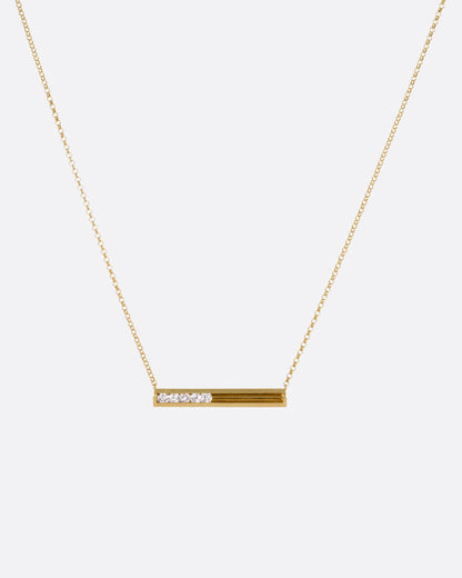 Yellow gold sliding diamond bar necklace, the bar hanging from its fine chain