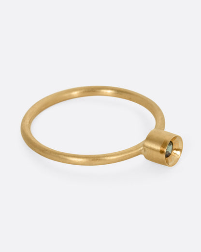 A yellow gold ring with a tourmaline, shown from the side.
