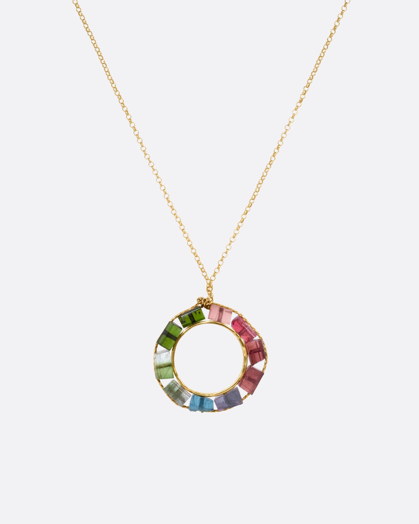 A yellow gold cable chain necklace with an open circular pendant featuring multicolored tourmalines. Shown from the front.