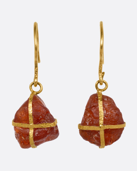 A pair of yellow gold drop earrings with gold wrapped raw rubelites, shown from the front.