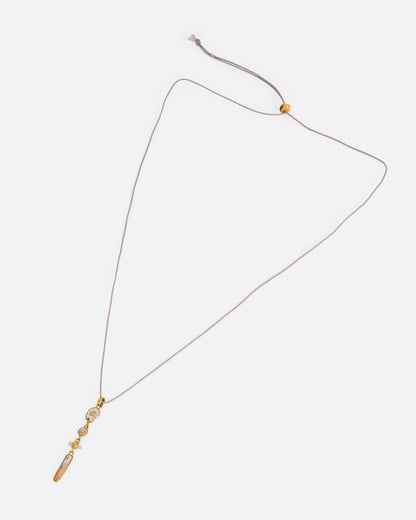 A yellow gold pendant with four gold wrapped pieces on a cord, shown from the front.