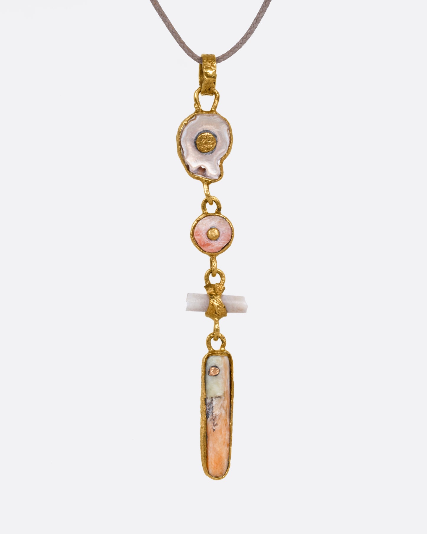 A yellow gold pendant with four gold wrapped pieces on a cord, shown from the front.