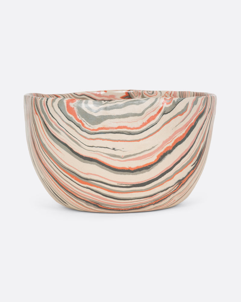 A ceramic bowl with peach, gray, and cream swirls. Shown from the front.