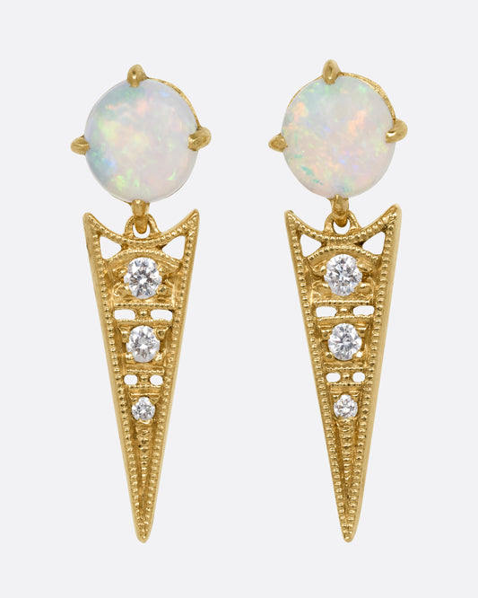 A pair of yellow gold earrings with prong set Australian opals and pointed drops with cutouts and a trio of diamonds. Shown from the front.