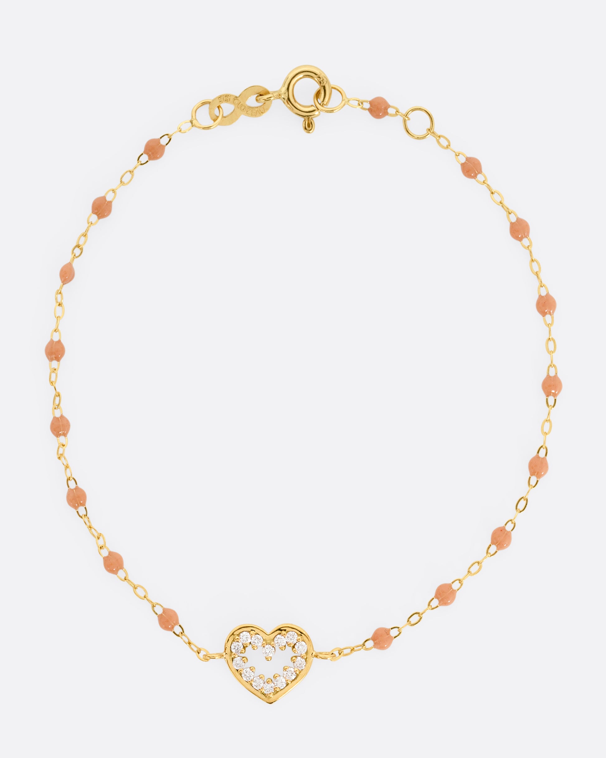 A yellow gold cable chain bracelet with a diamond lined heart charm and caramel brown resin droplets throughout. Shown from the front.