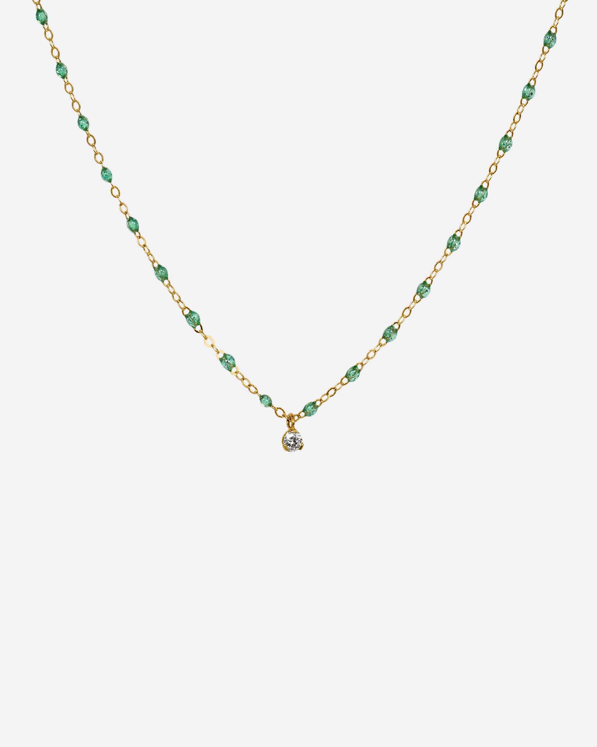 A yellow gold cable chain necklace with mint green resin droplets and a diamond charm at the center. Shown from the front.
