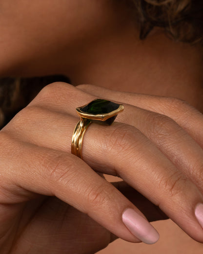 This ring is designed to showcase the tourmaline; the band is set off to one side and the setting is raised to allow for maximum light to pass through the stone. Shown on a finger.