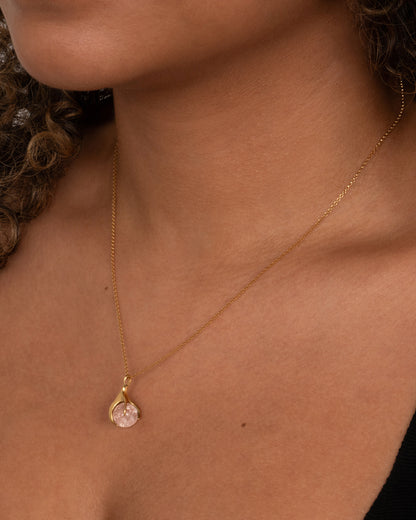 Kika Alvarenga Mini Concha necklace in yellow gold worn, a small pale pink tourmaline sphere held in a gold claw on a fine chain