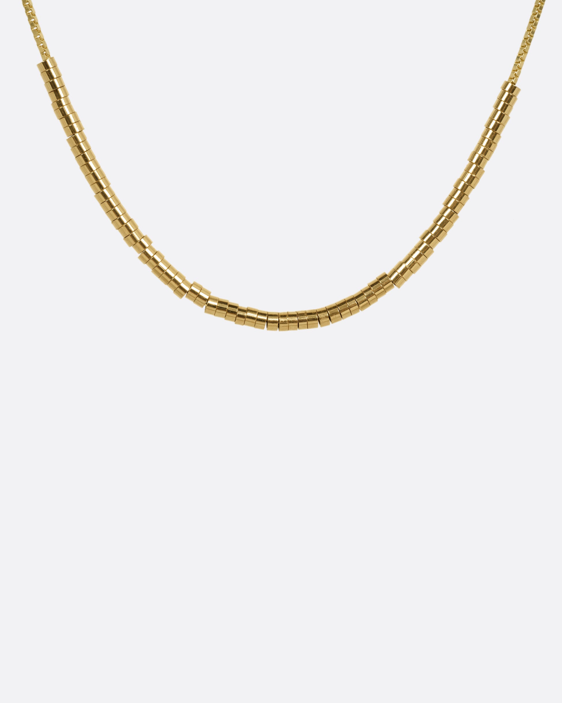 A yellow gold chain necklace with a queue of cylindrical gold beads, shown from the front.
